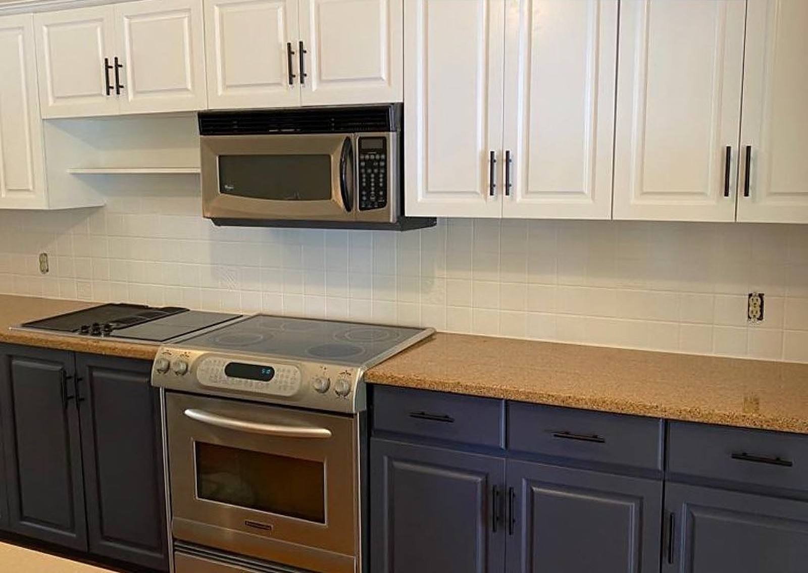 Kitchen with navy lower cabinets and white upper cabinets after spraying