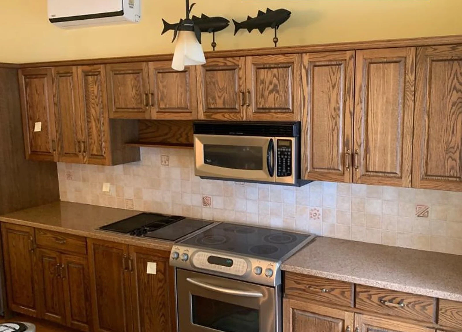 BEFORE: cottage kitchen with dark oak cabinets, yellow walls