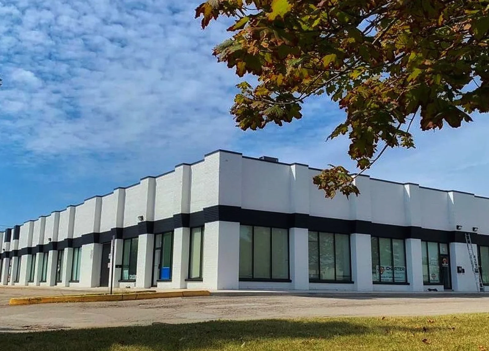 AFTER: Mississauga industrial complex painted white with black band, blue sky