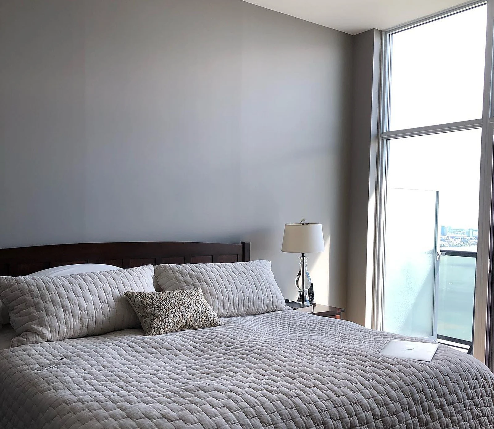 Lakeshore penthouse bedroom, grey walls, floor-to-ceiling windows