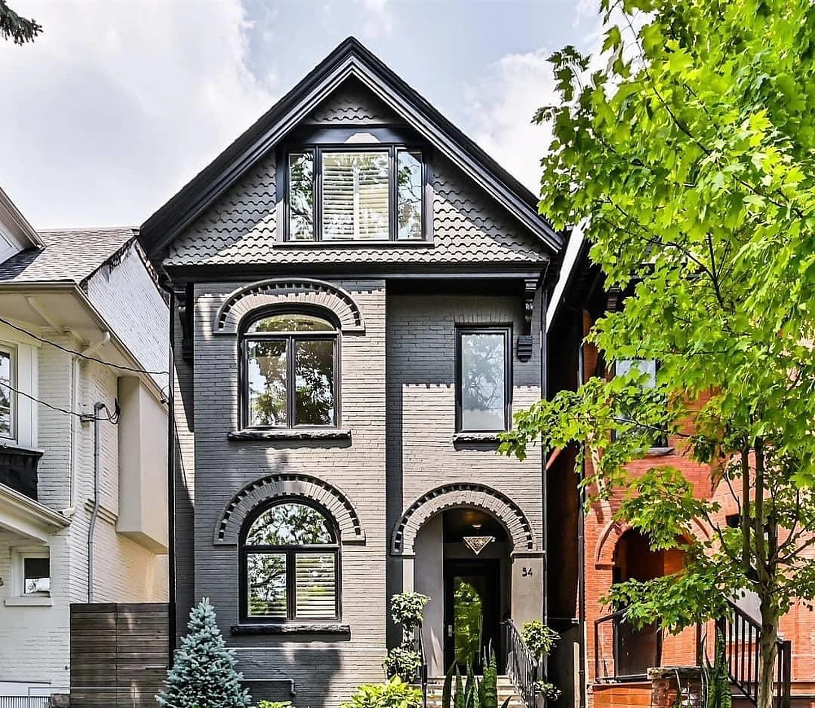 East-end Toronto Victorian house exterior painted charcoal/black brick, black trim