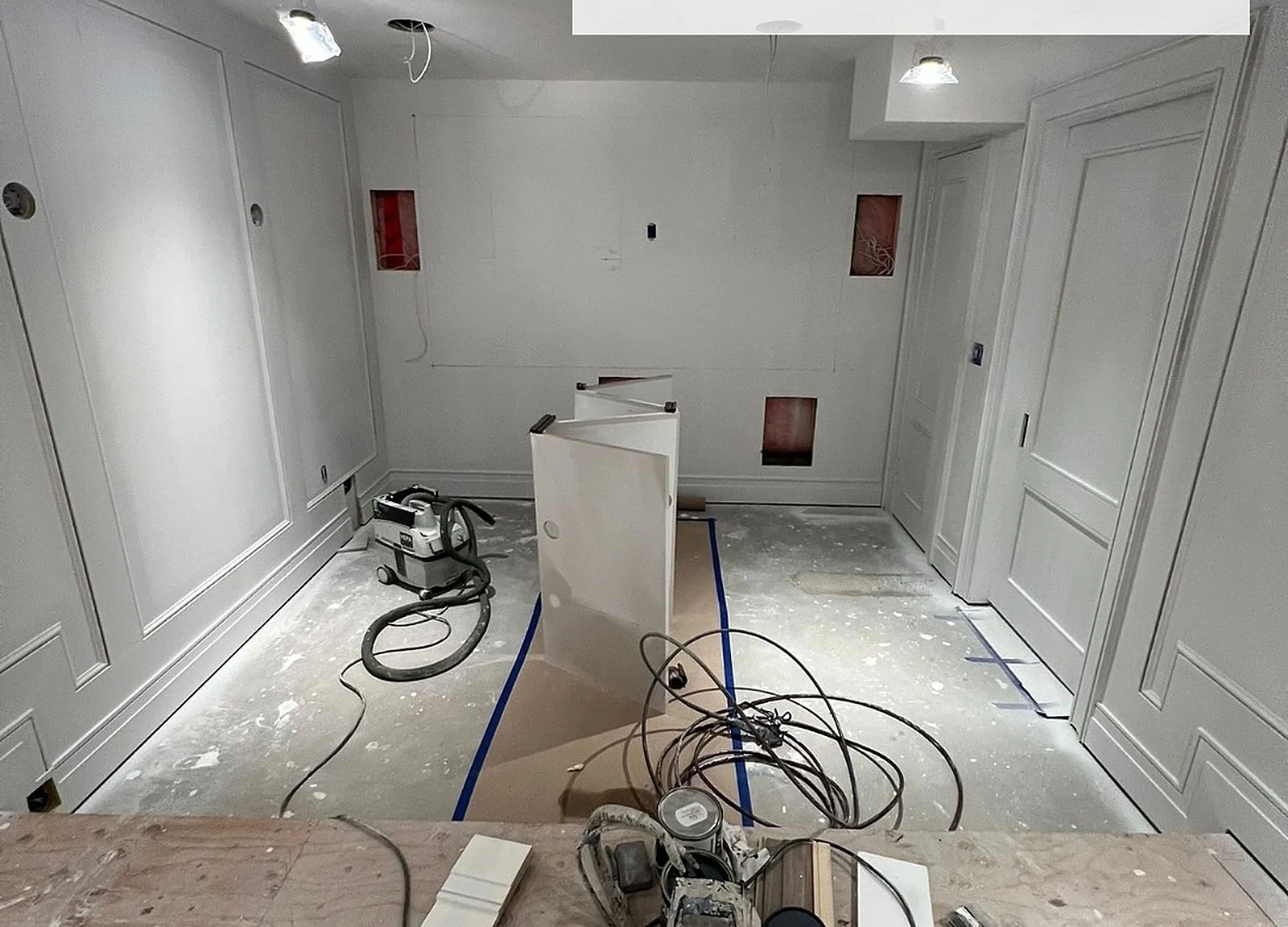 BEFORE: unfinished basement theatre with sprayer equipment