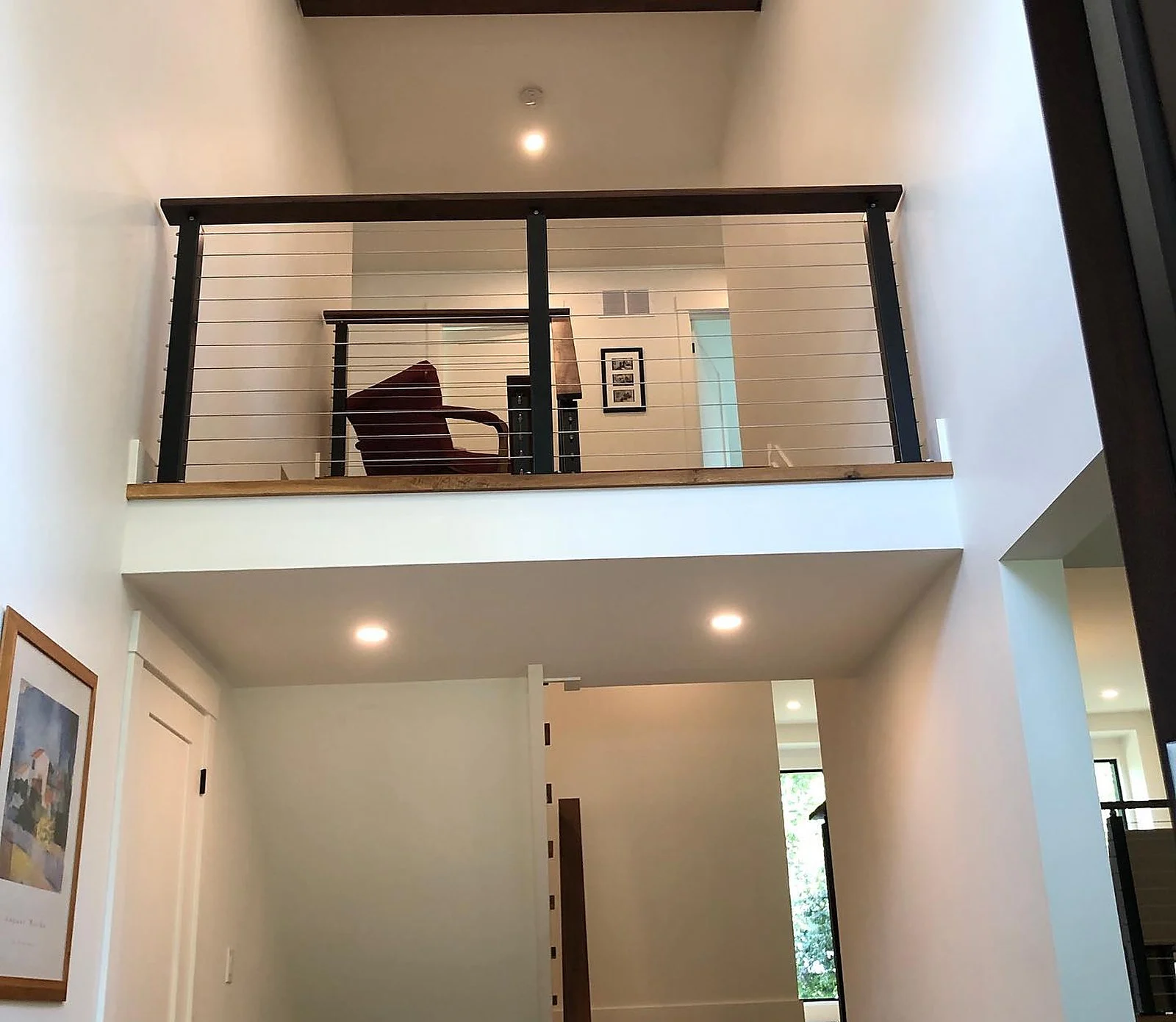 Open landing with cable railing, white walls