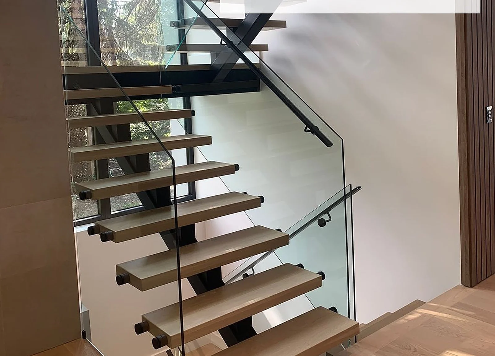 AFTER: floating staircase with stained oak treads and glass railing
