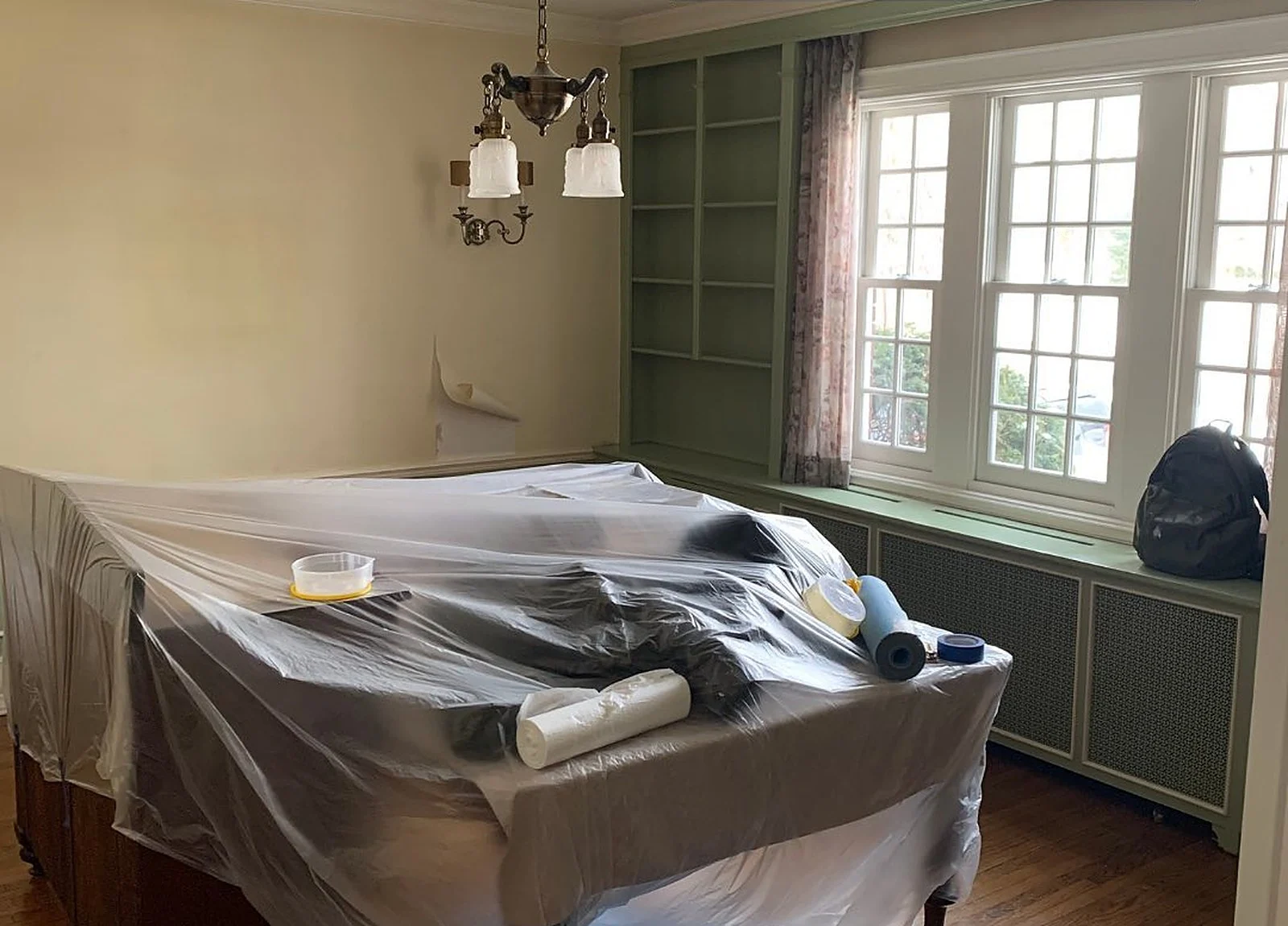 BEFORE: dining room masked with plastic, olive built-ins