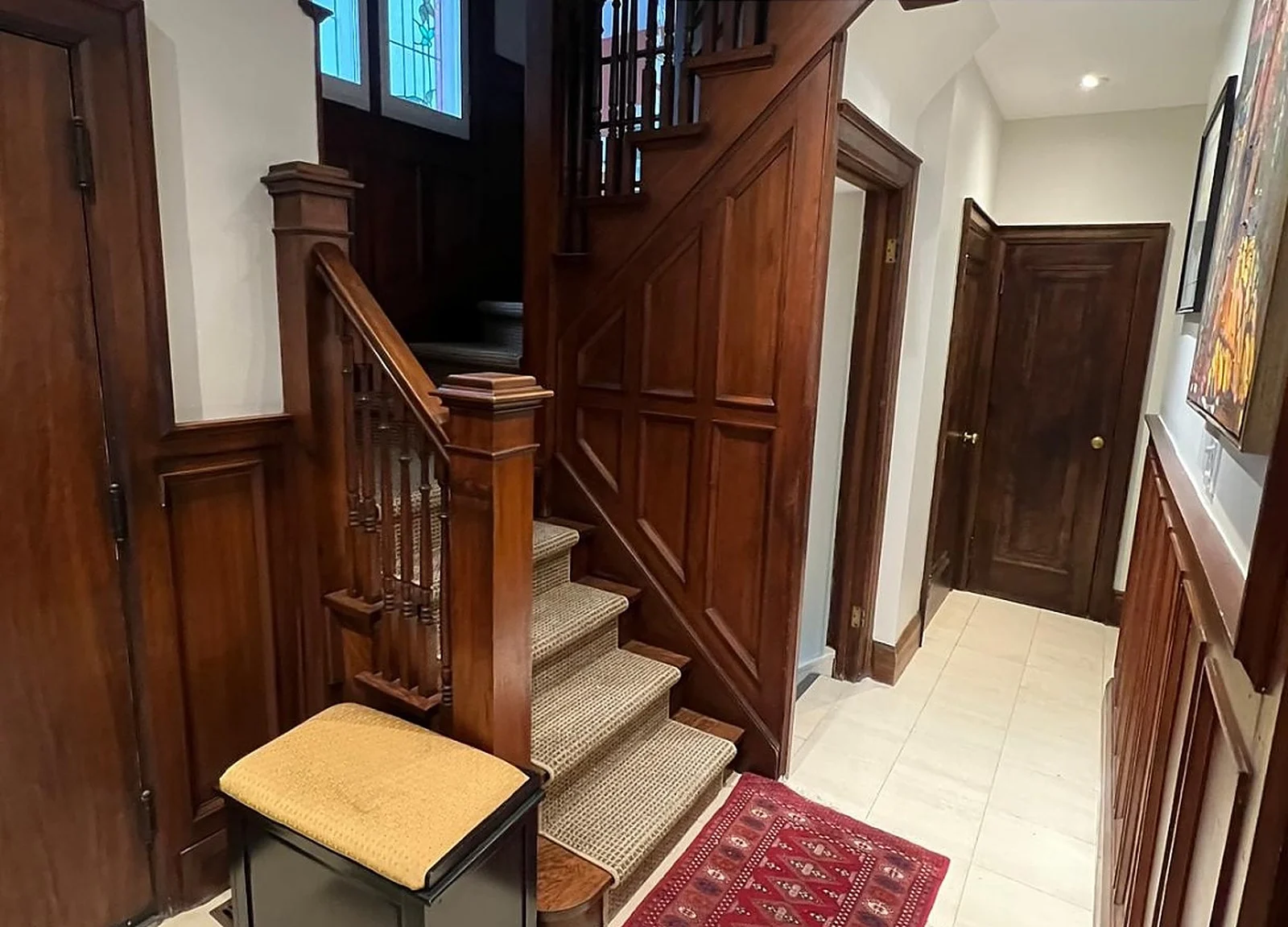 BEFORE: 1934 foyer with dark original wood staircase and panelling