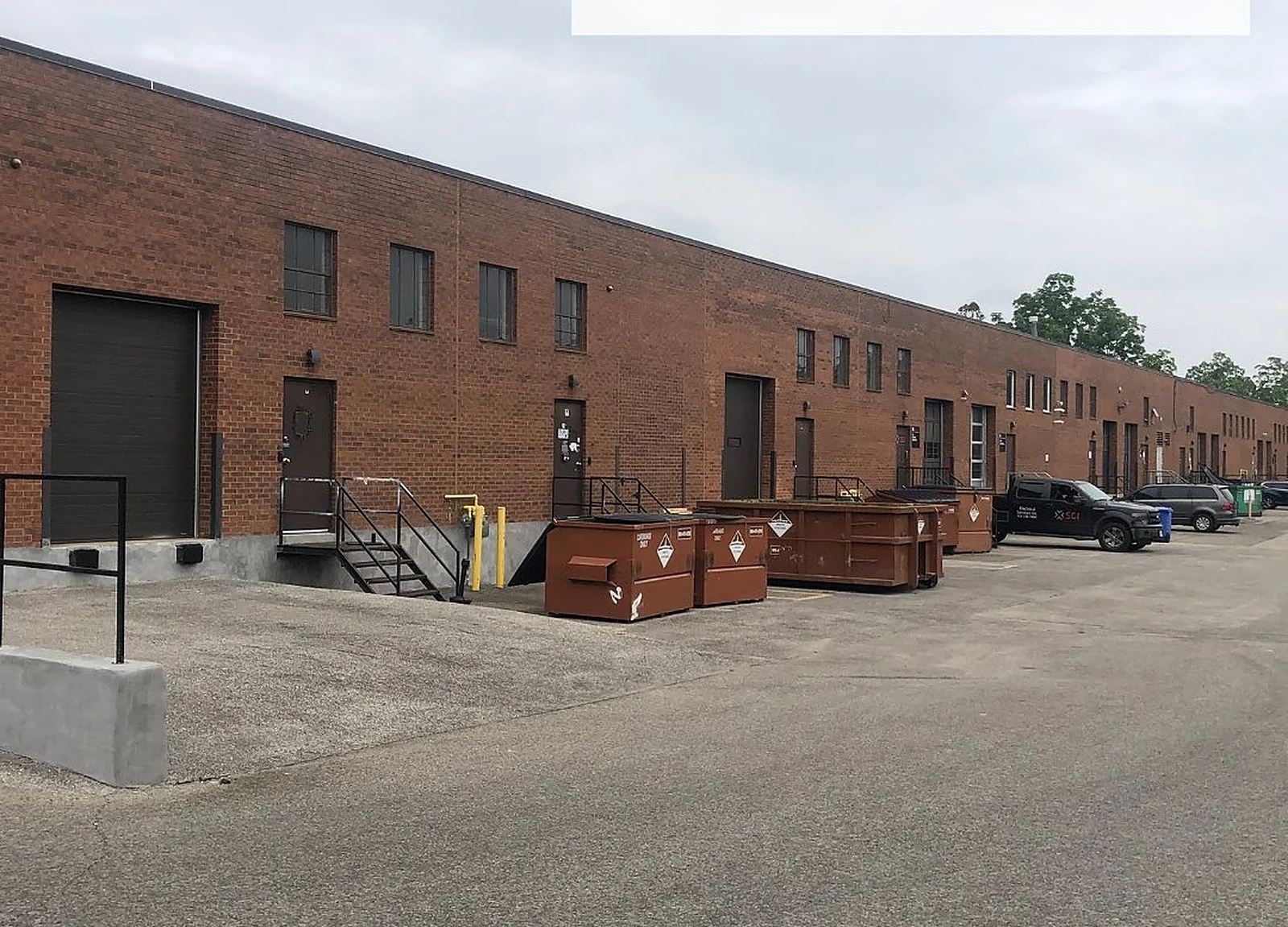 BEFORE: brown brick loading-dock building row
