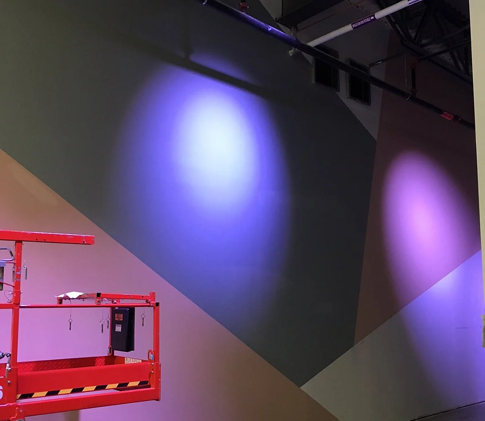 Nike store purple/grey wall with coloured lighting, scissor lift