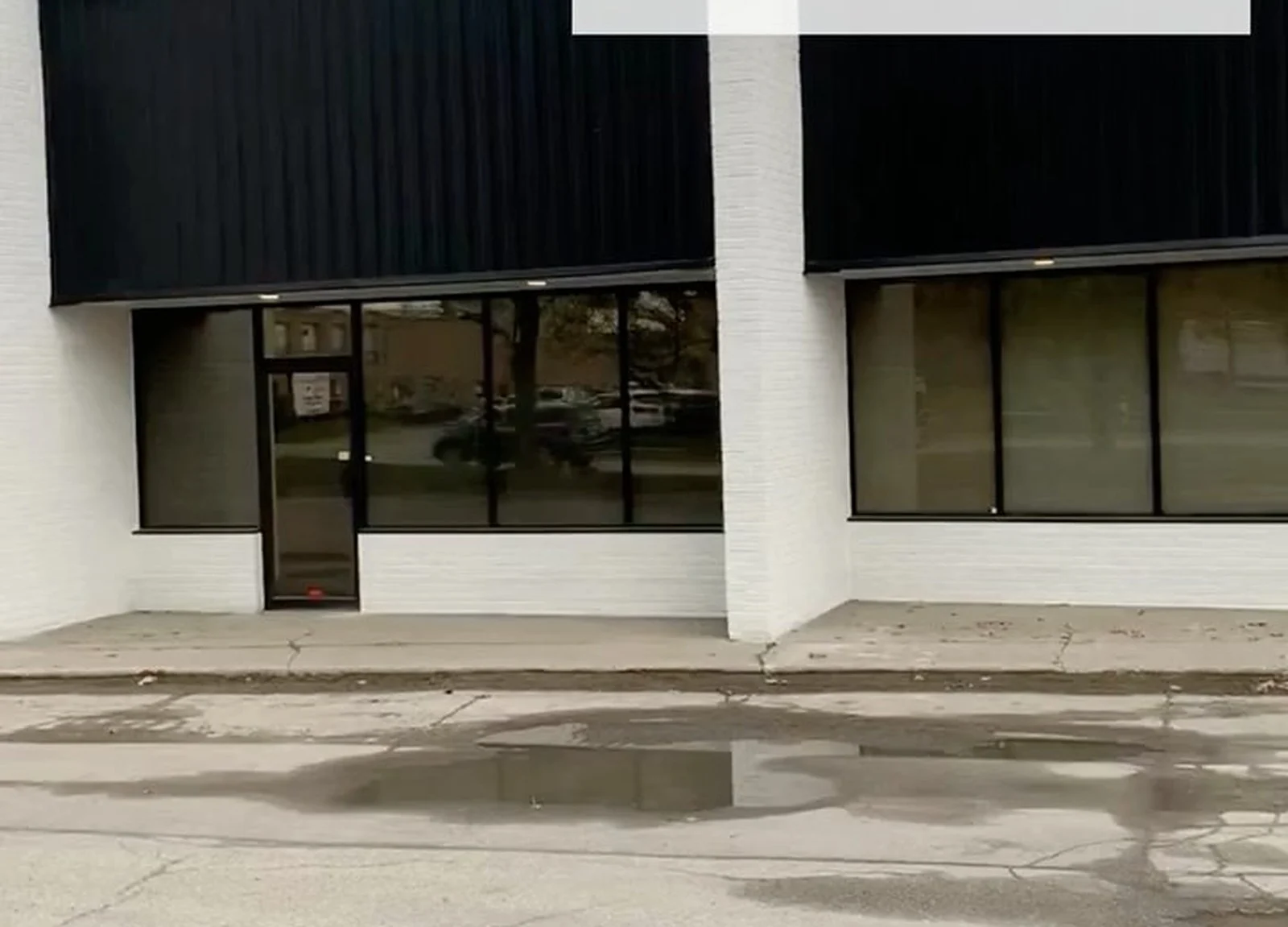 AFTER: white brick storefront, black siding