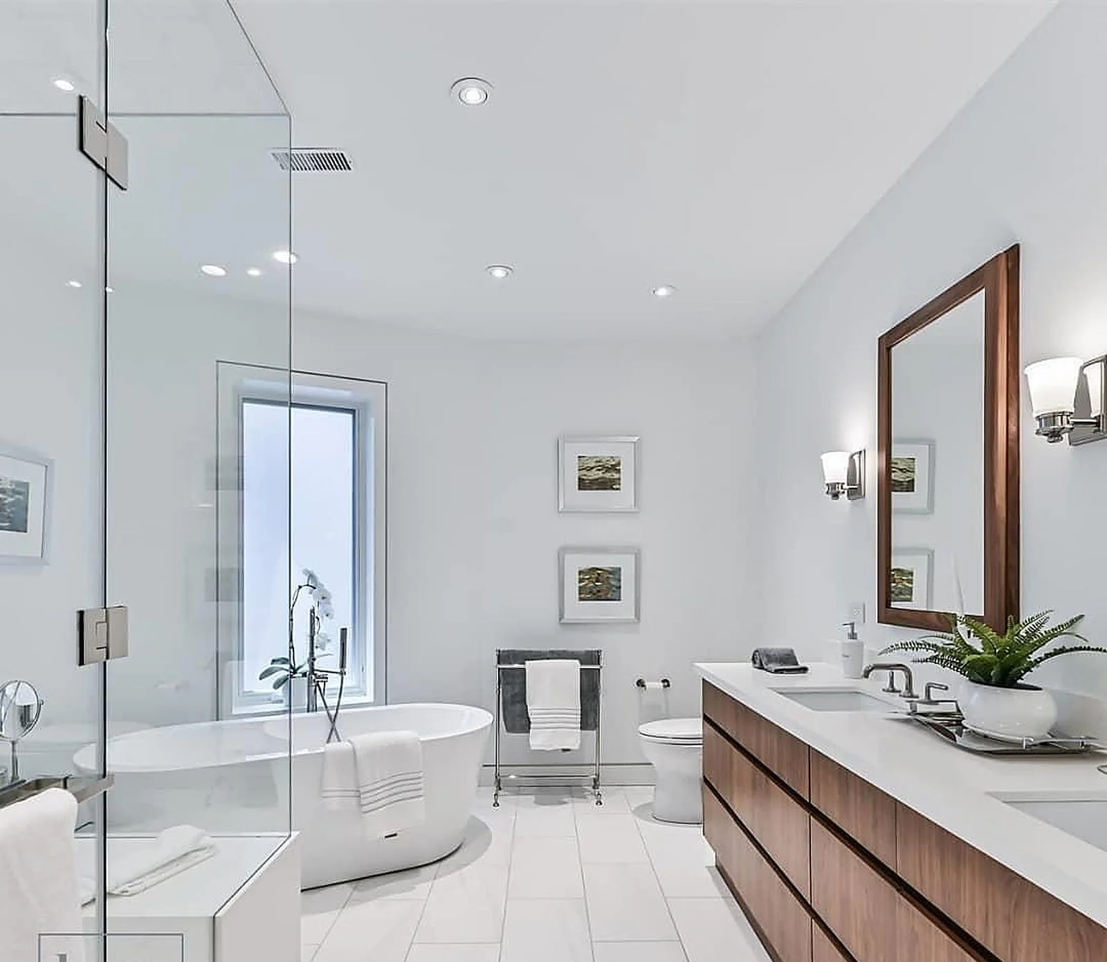 White ensuite bathroom with freestanding tub, wood vanity