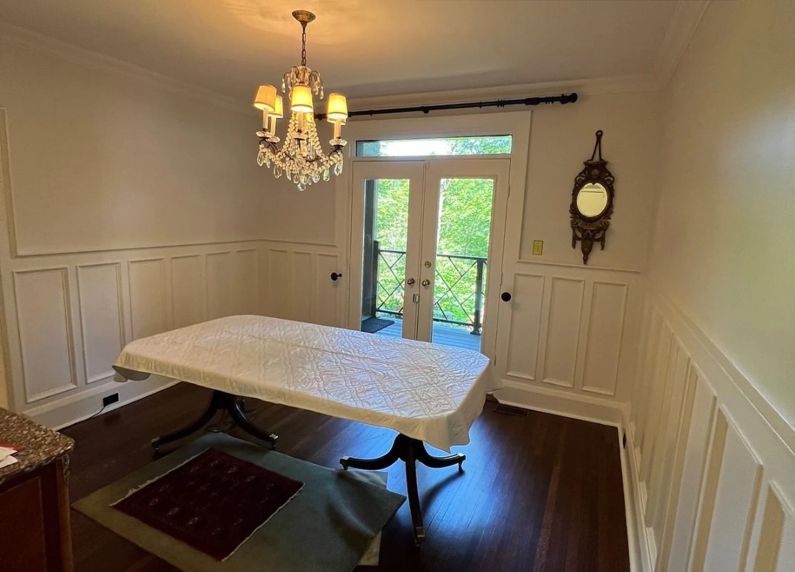 AFTER: dining room with white wainscoting, chandelier