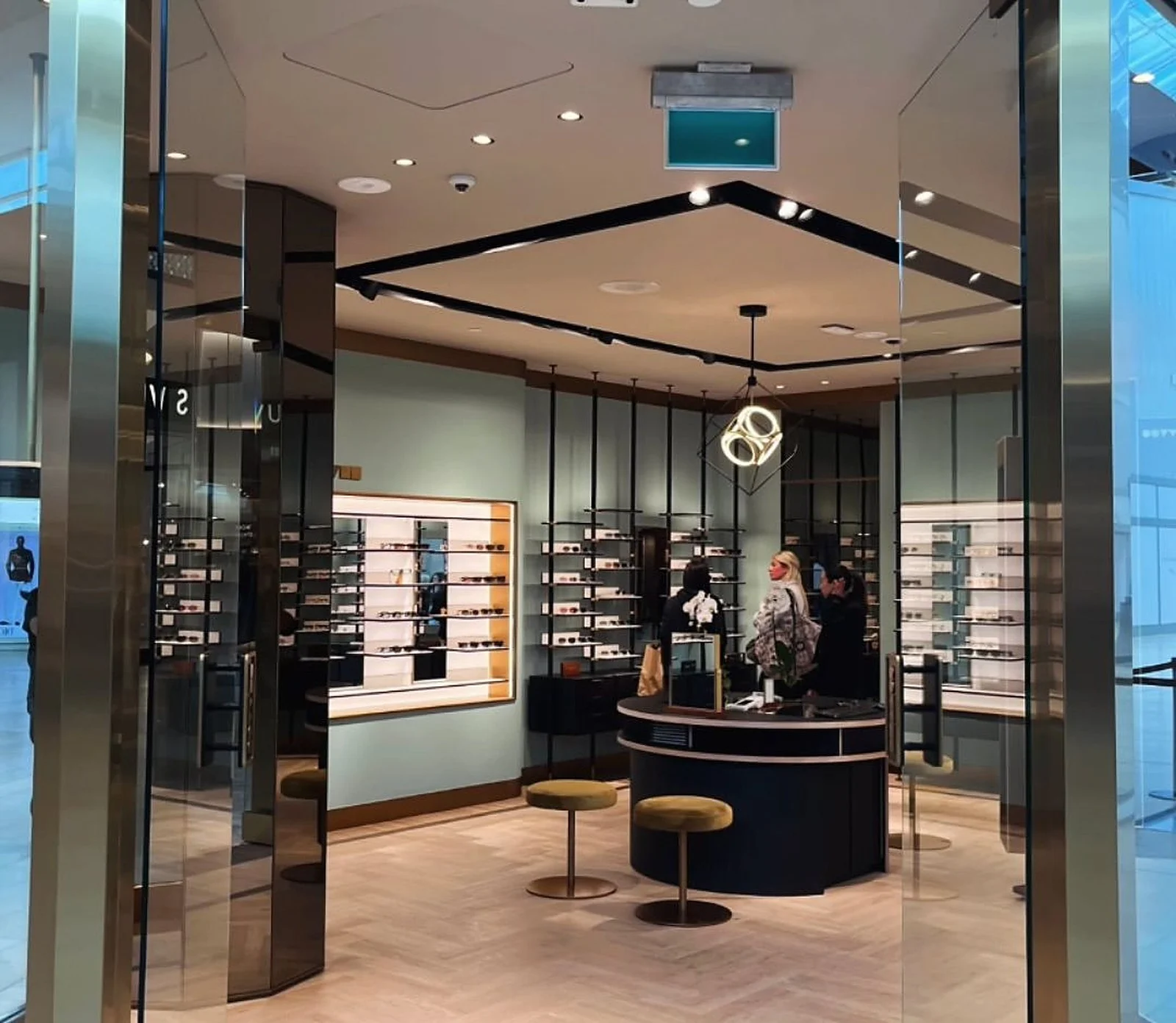 Mint-green retail interior with black and gold details