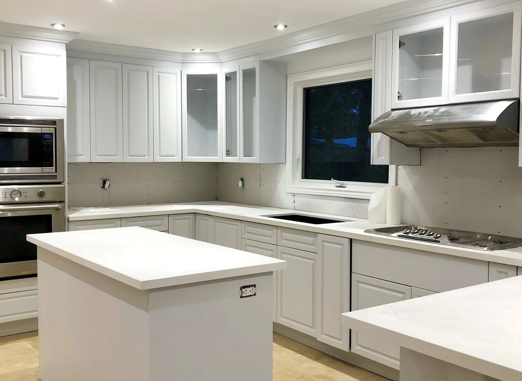 Kitchen with cabinets sprayed white and a white island
